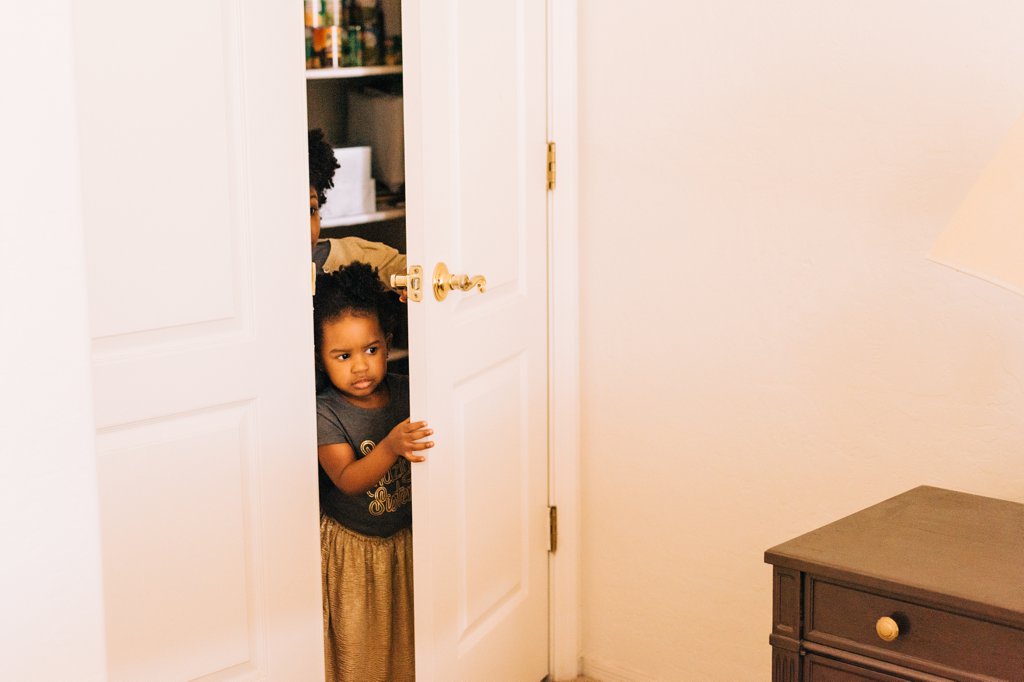 toddler girls peaking through bedroom door