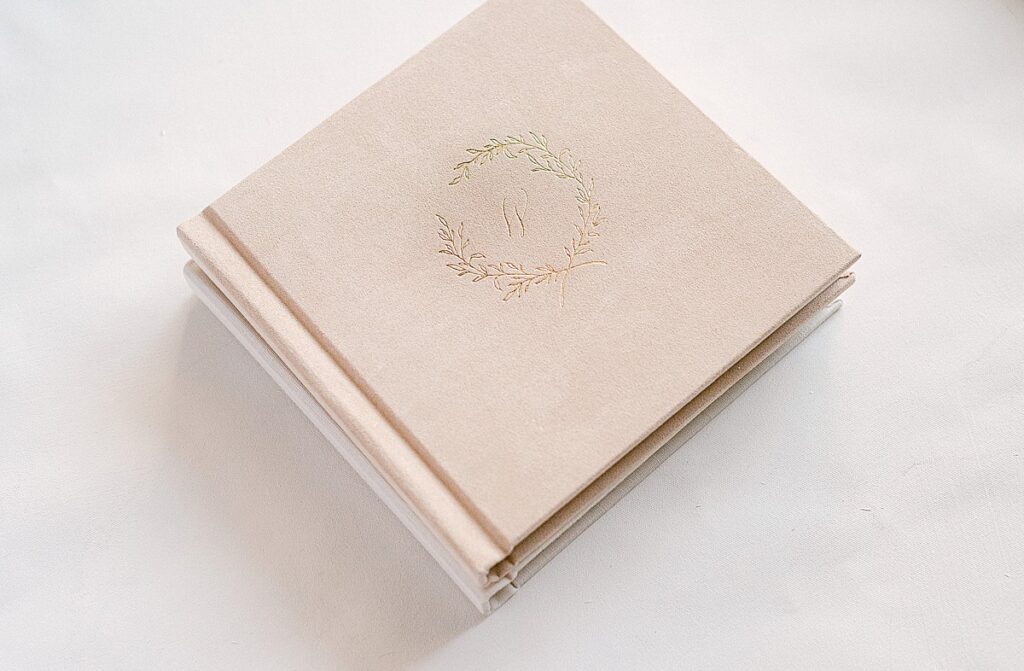 stack of heirloom albums in blush suede with gold foil debossing