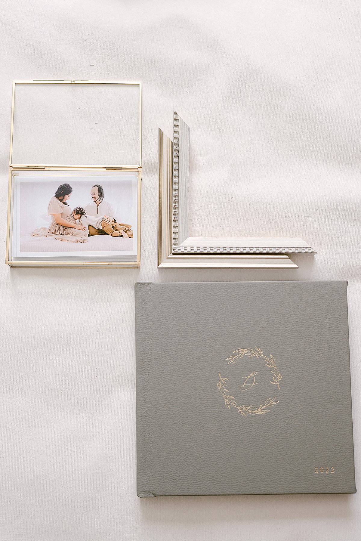 printed proofs in gold glass keepsake box next to heirloom album and frame moldings designed by scottsdale az photographer