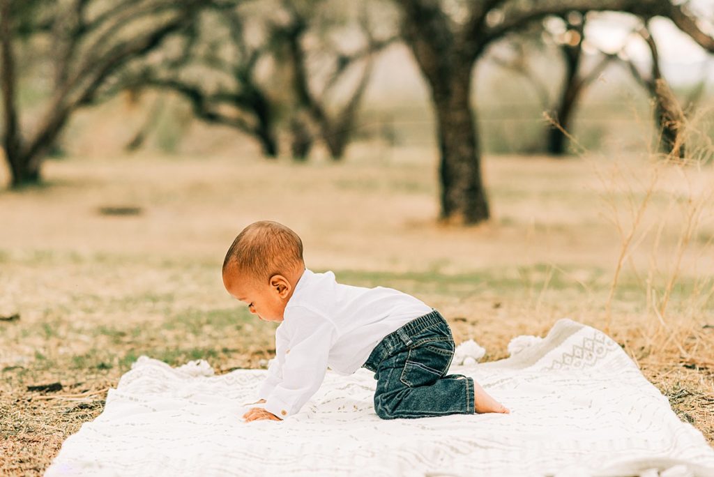 toddler boy exploring blanket at campground