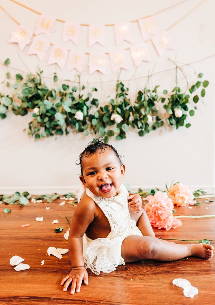 baby girl first-year birthday photo with eucalyptus, rose, and peony banner