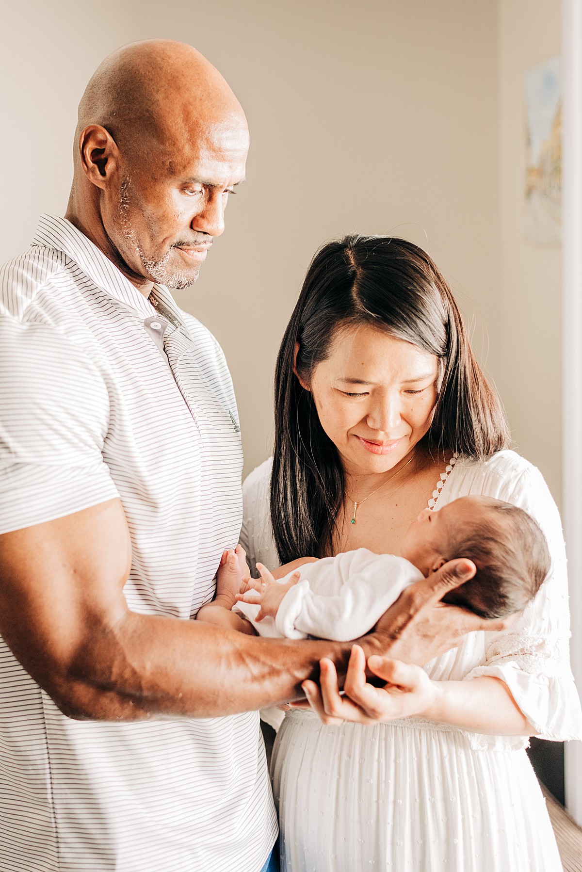 Parents holding newborn baby for in-home lifestyle newborn photos