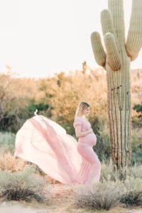 pink flowy maternity dress with mom standing next to saguaro cactus