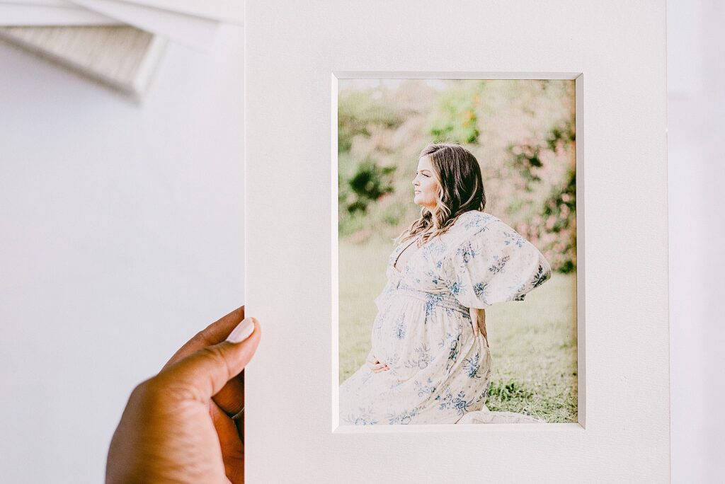 Hand holding loose print of maternity photoshoot