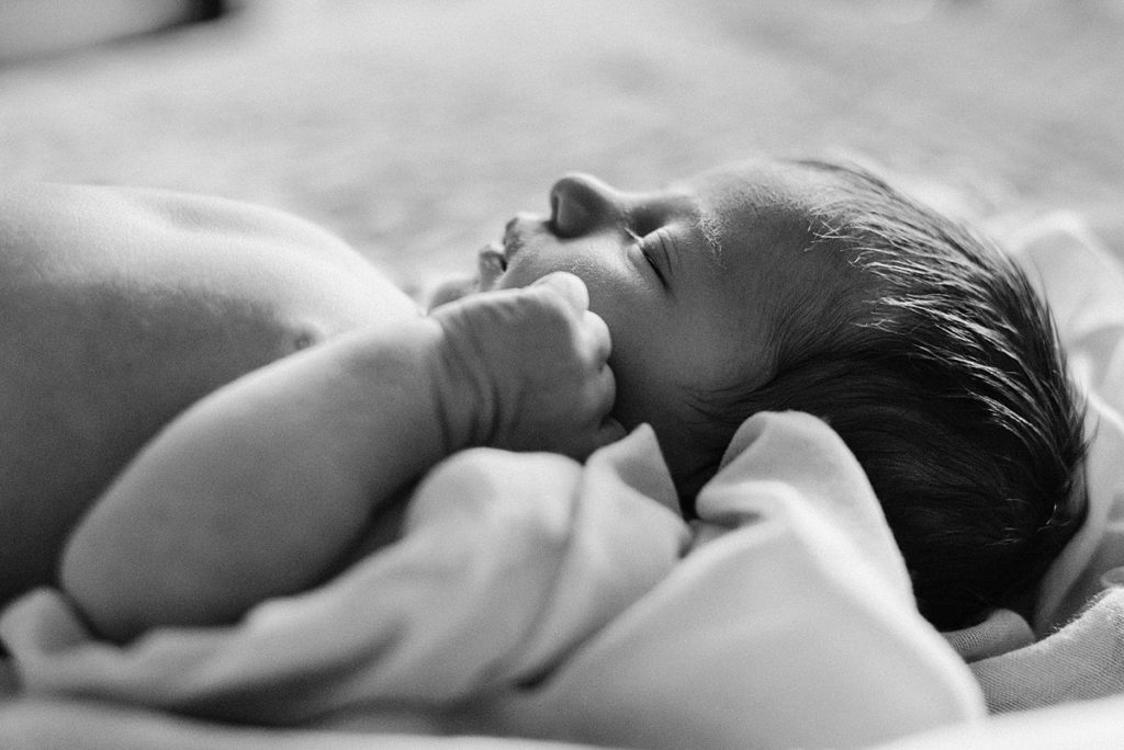 Side profile of newborn baby in black and white