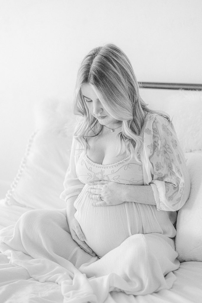 black and white intimate maternity photo of mom in light and airy photo studio