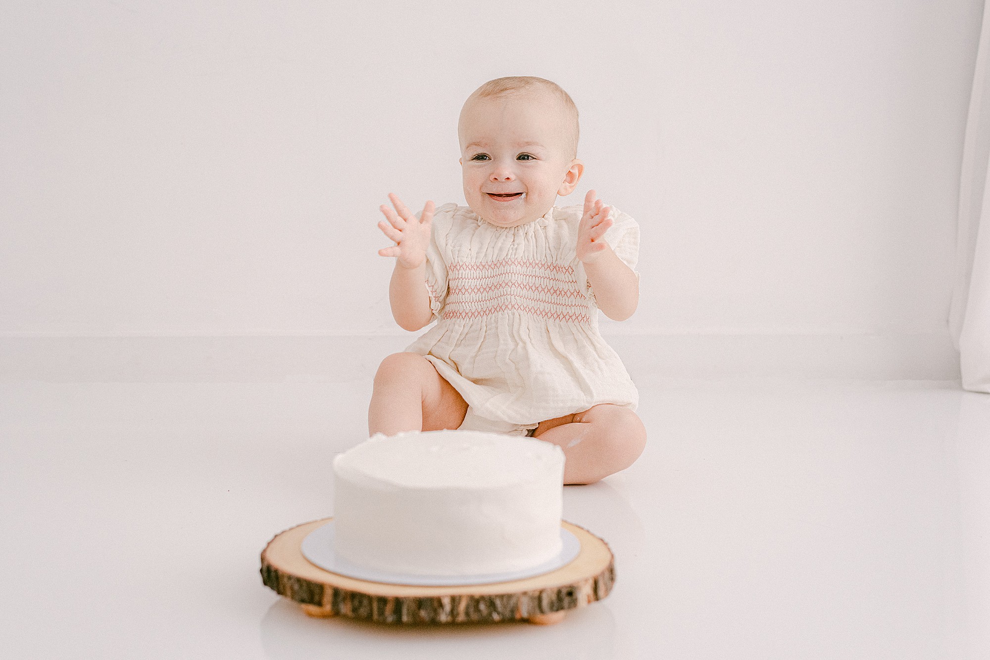 Baby's first-year cake smash photoshoot with plain white cake