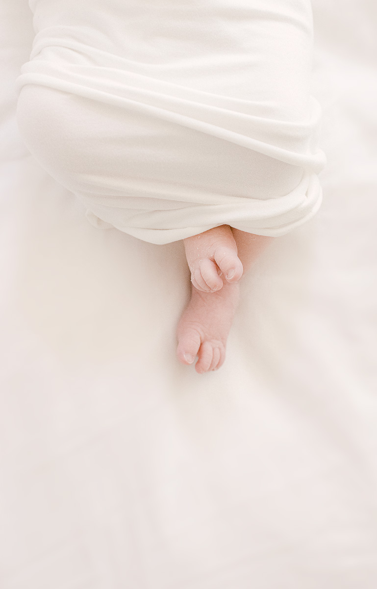 Fine art photo of newborn toes peeking out of swaddle
