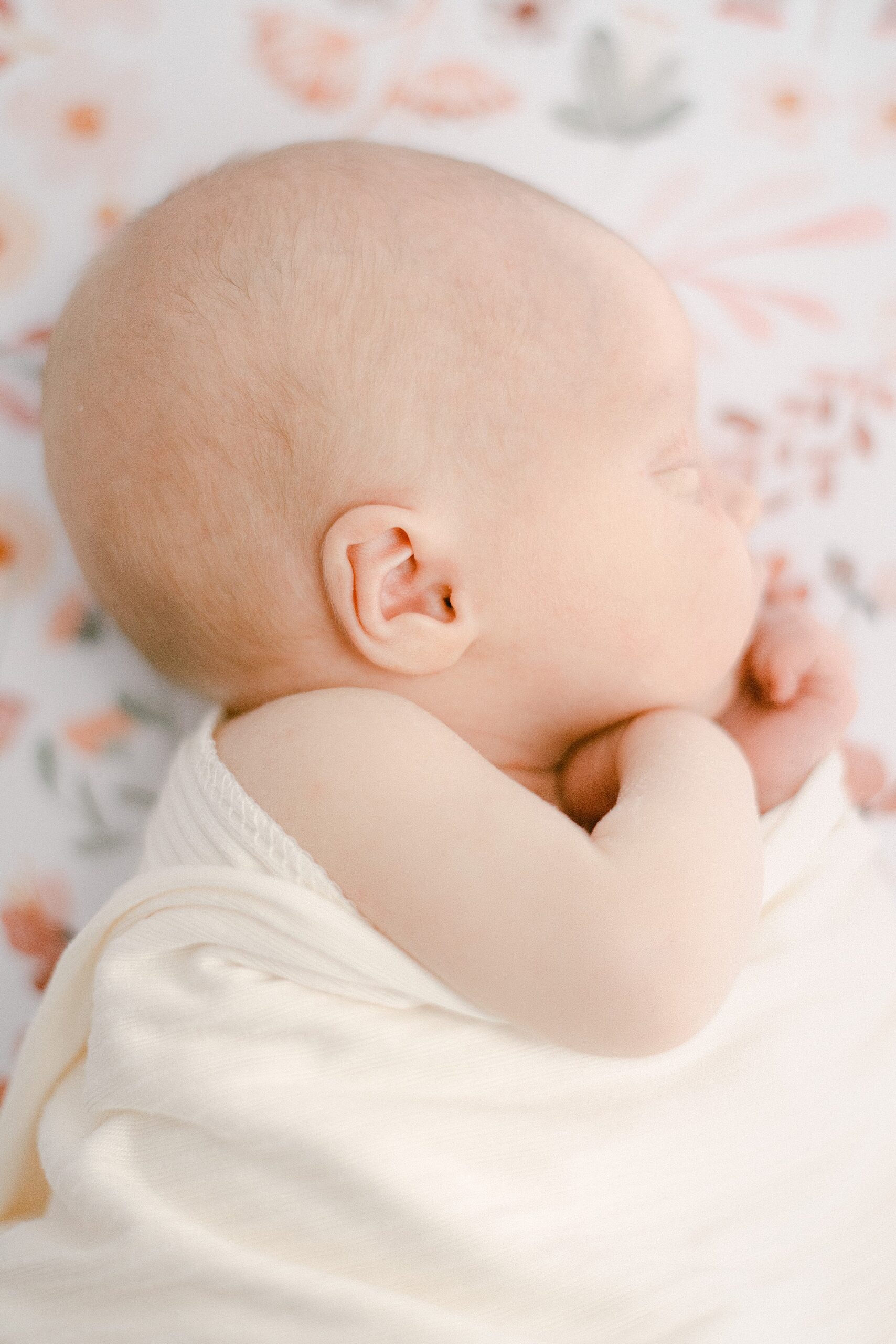 Side profile of newborn baby ear while baby is sleeping in nursery