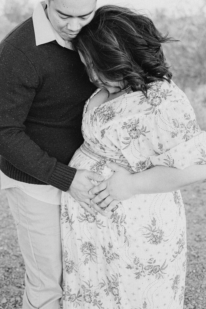 Closeup of mom and dad holding baby bump