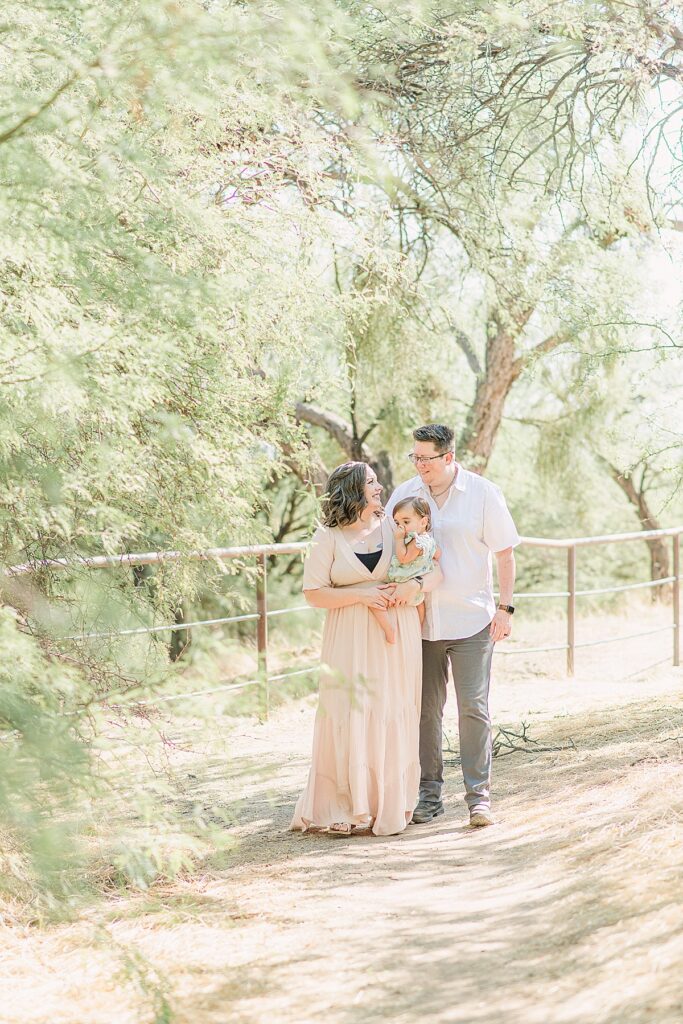 family of three walking through trees at coon bluff in arizona