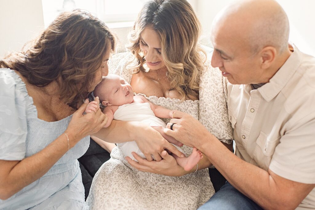mom with her parents while holding new grandchild