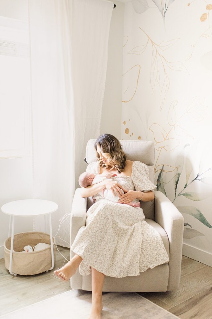 wide angle of mom in nursery holding baby boy in rocking chair